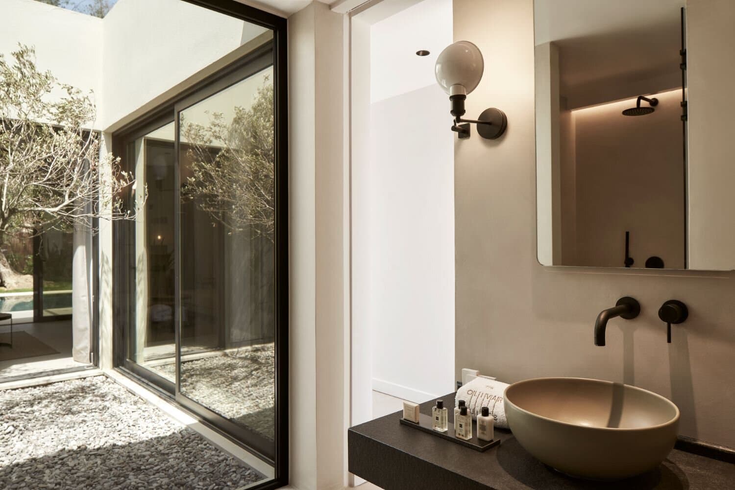 Bathroom detail with the pebbled courtyard beyond