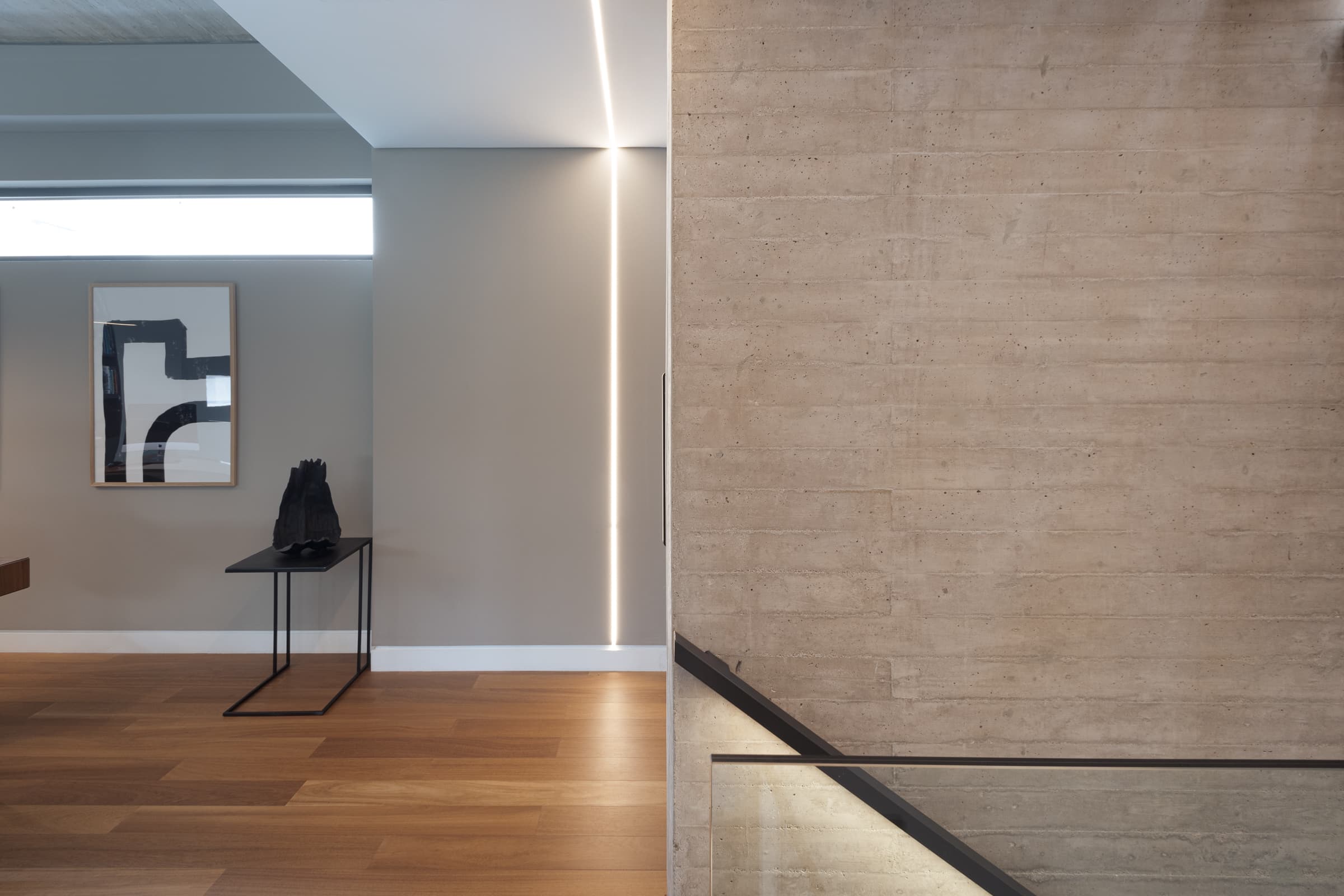Upper hallway along the board-formed concrete wall