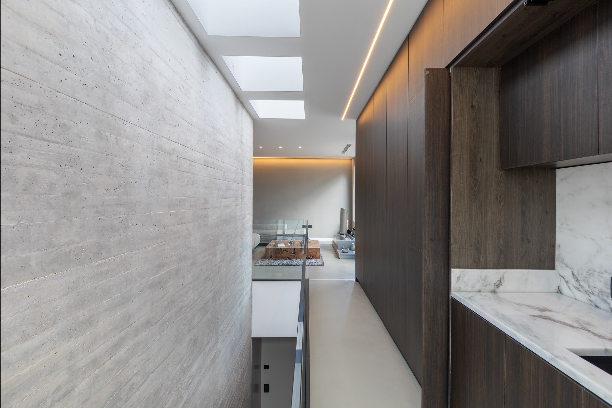 Mezzanine corridor between raw concrete and dark timber